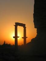 El sol aparece por detras de algunas de las columnas