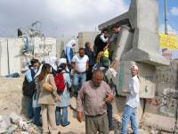 En cuanto desaparece el vehiculo del ejercito, la gente se abalanza sobre el muro para treparlo. La gente se ayuda solidariamente para pasar la compra del da, la mochila del colegio, etc