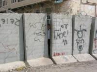 Un nio se asoma entre los bloques. En uno de ellos puede leerse 'Ghetto Abu Dis'. No deja de ser asombrante la candidez e inocencia con la que los nios palestinos se enfrentan a este tipo de situaciones