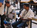 Hombres vistiendo el manto de plegarias o talit gadol, y el tefiln, que es el cordn de cuero que rodea su brazo izquierdo (o el brazo con el que no escribe) y que lleva unido dos cajas, una de ellas se coloca en el brazo, y la otra en la cabeza 